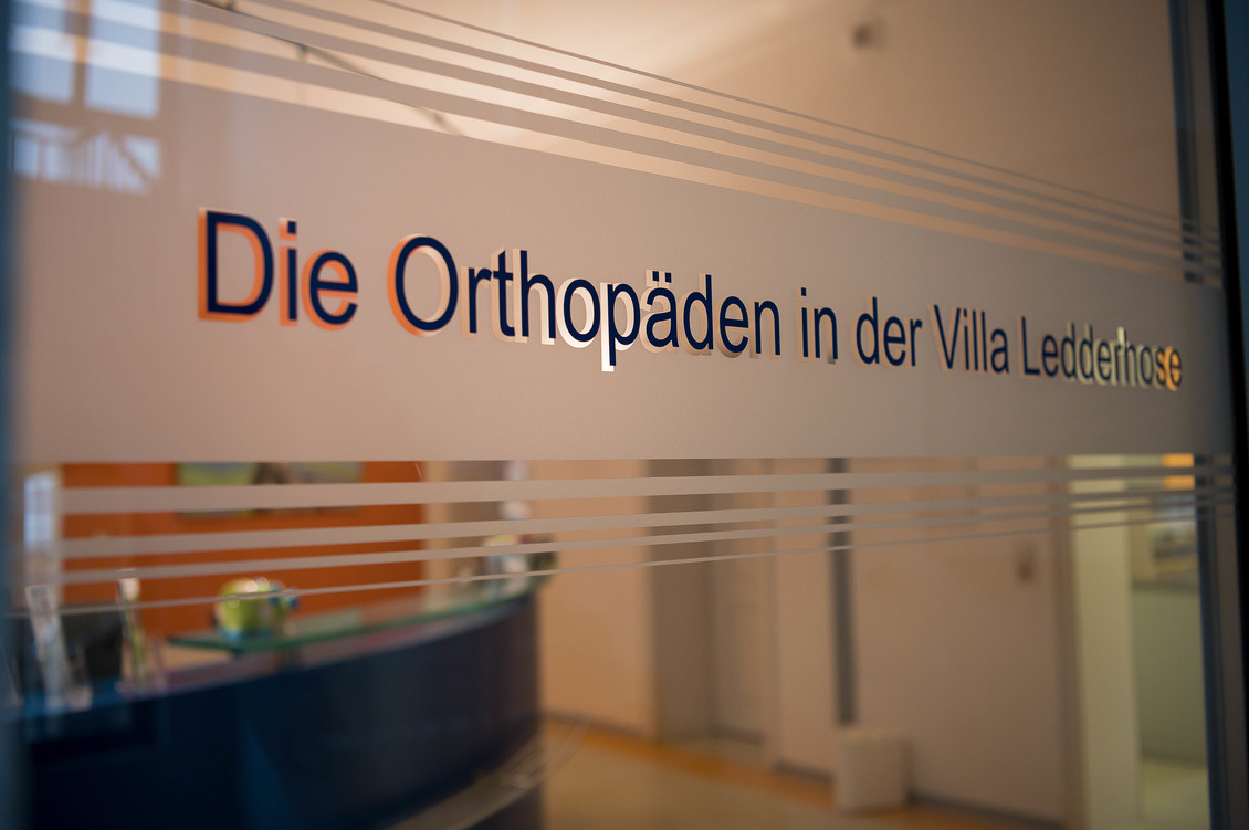 Glaswand mit dem Schriftzug Die Orthopäden in der Villa Ledderhose